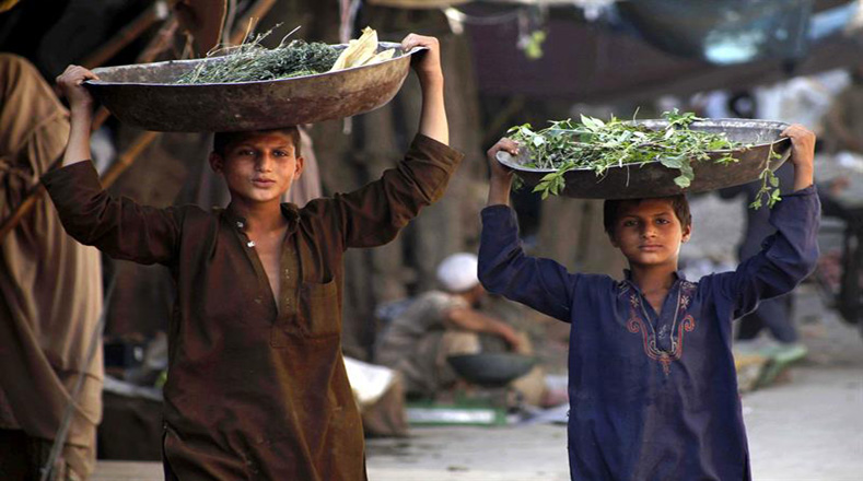 Un par de niños paquistaníes venden verduras en Peshawar (Pakistán).