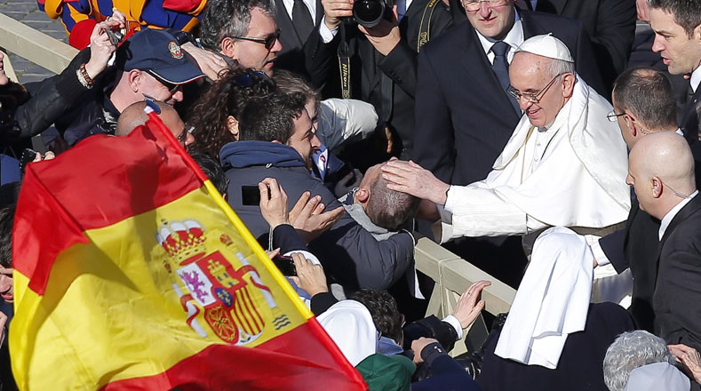 Los feligreses llevan a un joven discapacitado para que el Papa lo bendiga.