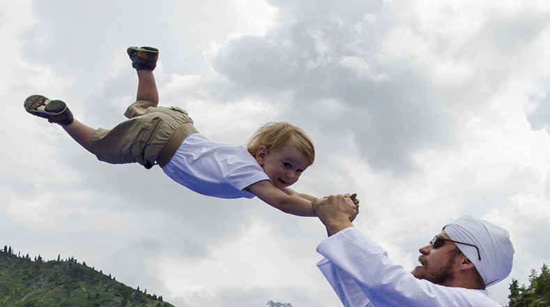Un hombre juega con un niño durante la celebración del Día Internacional del Yoga en pista de patinaje Medeo, en Kazajistán.