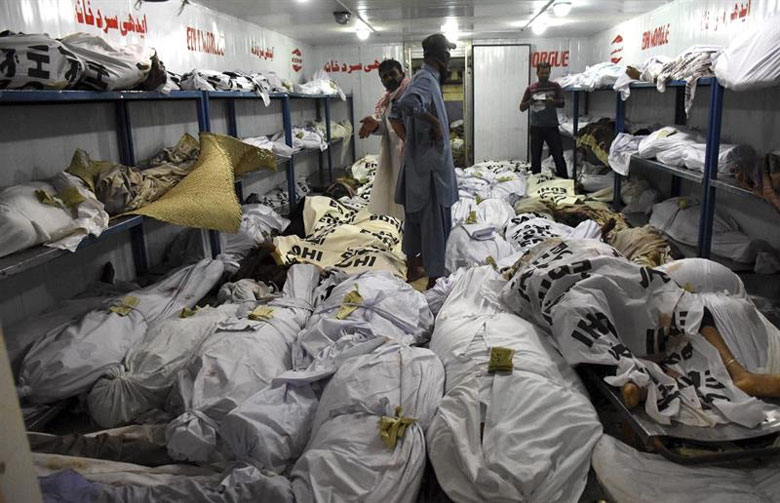 Varios operarios apilan cuerpos de víctimas afectadas por golpes de calor en una morgue en Karachi. 