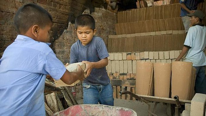 Niños de El Salvador trabajan en una fábrica de ladrillos.