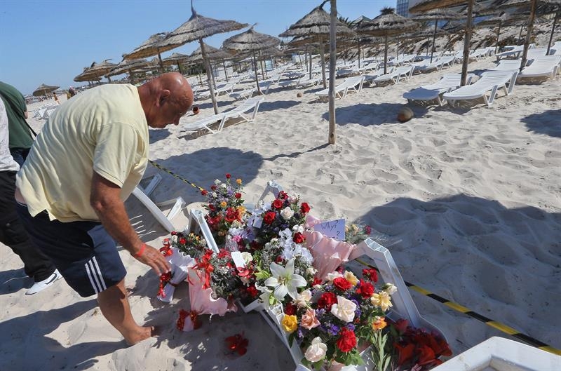 Una persona coloca flores en homenaje a las víctimas del ataque terrorista en Túnez.