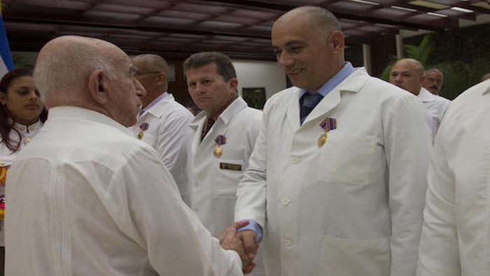 El Segundo Secretario del Partido Comunista Cubano, José Machado, saluda al Dr. Félix Báez, quien estuvo contagiado de Ébola durante la misión.