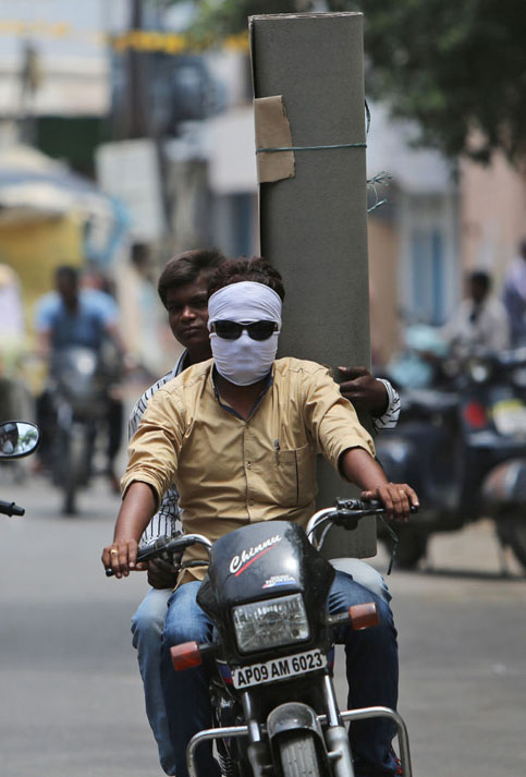 Un mototaxista , trata de proteger su rostro con tela y gafas oscuras.