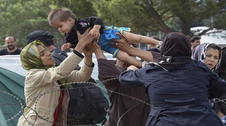 Una madre se reúne con su hijo después de que fueron separados el día anterior cuando los inmigrantes intentaron romper el cordón de las fuerzas especiales de la policía de Macedonia para desde Grecia.