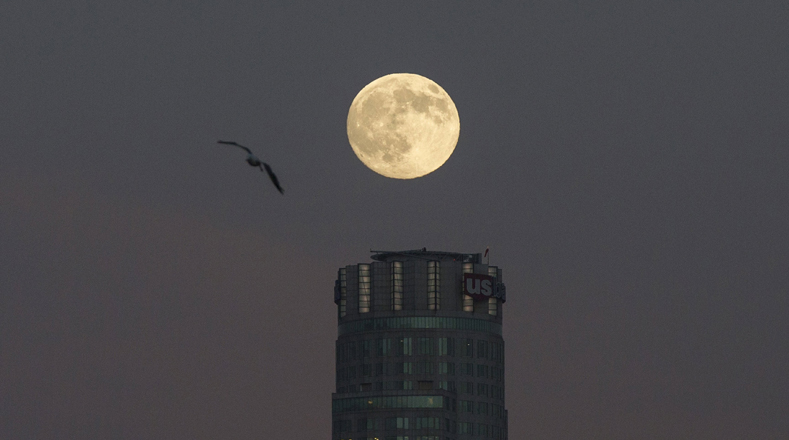 La luna se representa la cima de un edificio del centro de Los Ángeles.