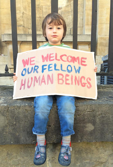 Un niño sostiene un cartel de bienvenida en Oxford, Inglaterra.