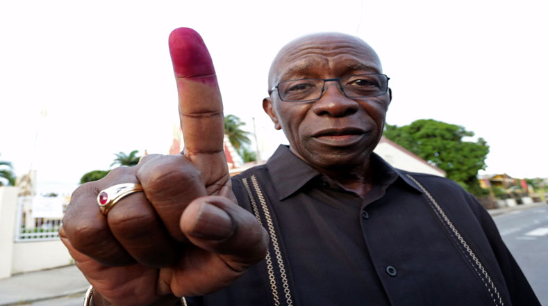 El exvicepresidente de la FIFA Jack Warner saludó luego de ejercer su derecho al voto en las elecciones generales de Trinidad y Tobago en un colegio electoral en Arouca.