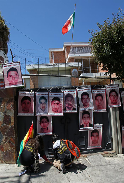 Jóvenes en Bolivia pegan imágenes de los 43 frente a la sede de misión diplomática de México en ese país.