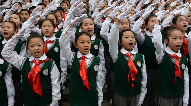 En el acto, escolares entonaron una canción patriótica vestidos con camisas blancas y pañuelos rojos, el uniforme del Cuerpo de Jóvenes Pioneros. 