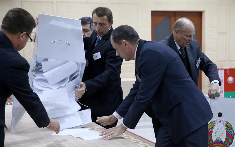 Personal de la Comisión Electoral vacía una urna después del cierre de colegios electorales durante las elecciones presidenciales en Minsk, Bielorrusia.