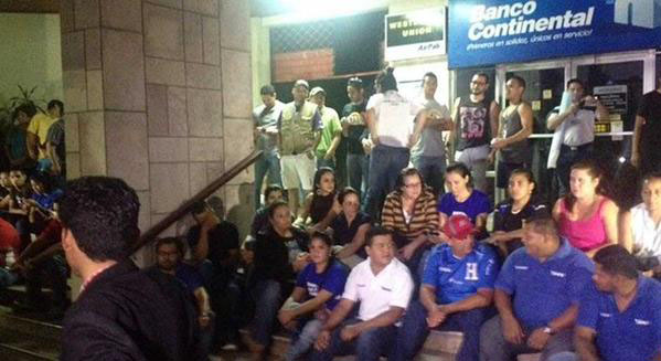 Un grupo de clientes frente a una agencia del Banco Continental en Honduras.
