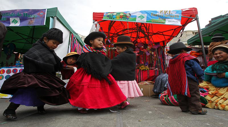 Niños bolivianos bailan junto a los altares con motivo de la celebración del Día de los Muertos. En ese país se cree que a mediodía del 1 de noviembre las almas de los difuntos descienden desde los cielos para comer y beber lo que en vida les gustaba, y por ello, se montan estos altares con comida, panes y bebidas.