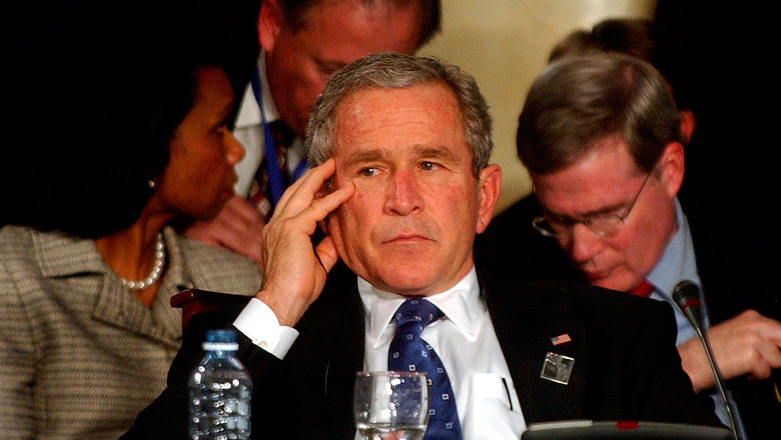 El expresidente estadounidense George W. Bush, escucha alguna de las intervenciones en la Cumbre Iberoamericana de Mar del Plata.  Detrás su canciller, Condolezza Rice, responsable de la propaganda diplomática que permitió la invasión y guerra de Irak.