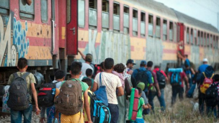 Refugiados abordan de un tren después de cruzar la frontera Macedonia - griega.