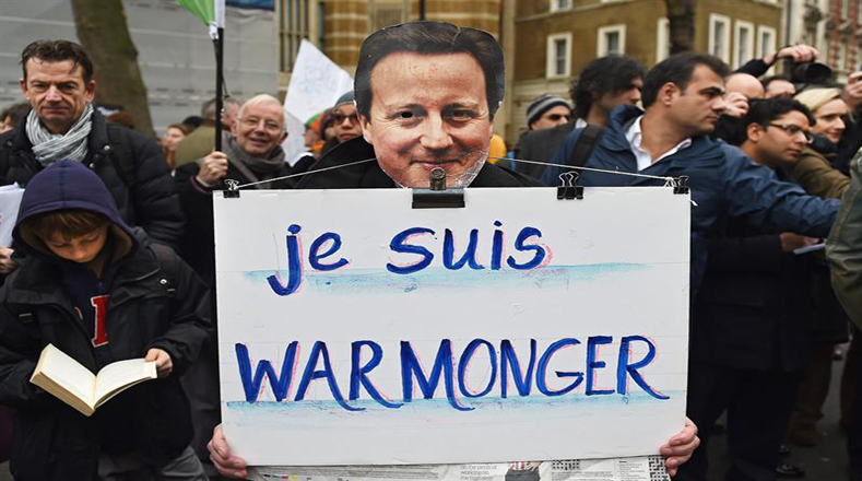 "Soy belicista" se puede leer en la pancarta que esta junto a una imagen del primer ministro Cameron.