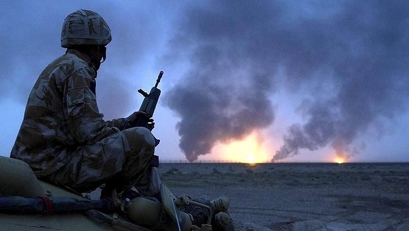 La foto muestra a un soldado británico viendo pozos de petróleo en fuego en el sur de Irak en marzo de 2003.