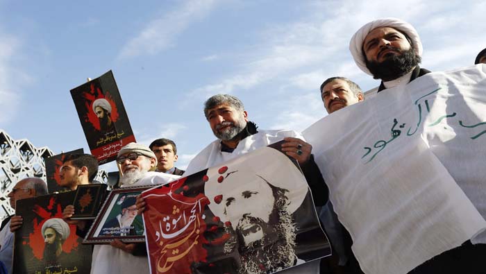 Manifestantes iraníes muestran carteles con el retrato del clérigo y dirigente chií, Nimr Baqir al Nimr, durante una protesta convocada en Teherán.
