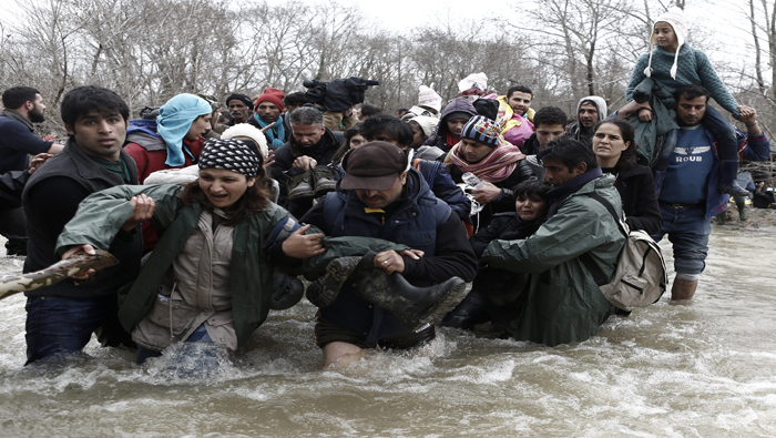 Refugiados en un campamento cerca de la villa Idomeni usan una cuerda para cruzar un río en la frontera con Macedonia.