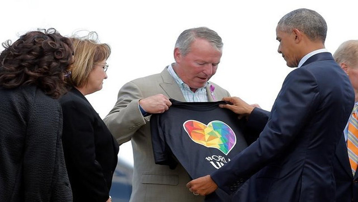 El presidente Obama recibió una camiseta del Alcalde de Orlando, Buddy Dyer a su llegada en Orlando, Florida.