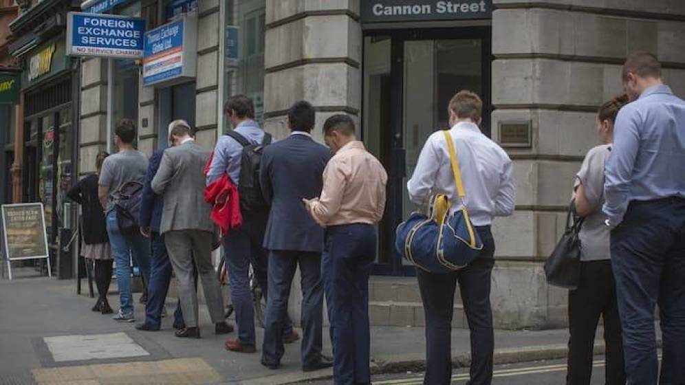 Londinenses hacen colas en casas de cambio para cambiar sus monedas.