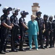 La candidata presidencial demócrata, Hillary Clinton, saluda a policías que la escoltaron hacia el aeropuerto de Reno, Nevada, tras un acto de campaña, el jueves pasado.