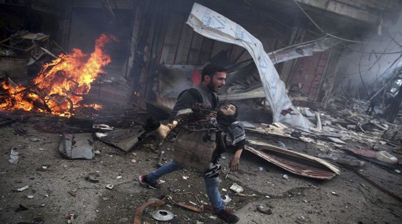 La foto ganó el segundo premio en la categoría de temas de actualidad. En ella se muestra a un hombre sirio que lleva en sus brazos a un niño asesinado durante los bombardeos en la ciudad de Douma (Siria) el pasado siete de noviembre de 2015.