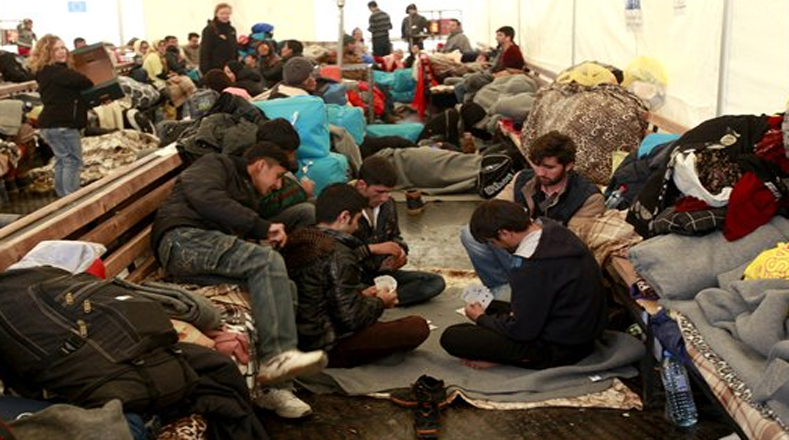 Estos refugiados juegan cartas mientras esperan cruzar la frontera a Serbia. 