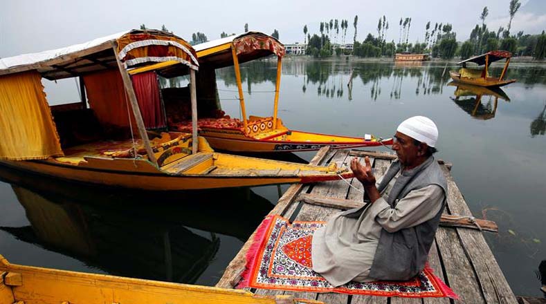 Un barquero cachemir reza en el lago de Srinagar (India).