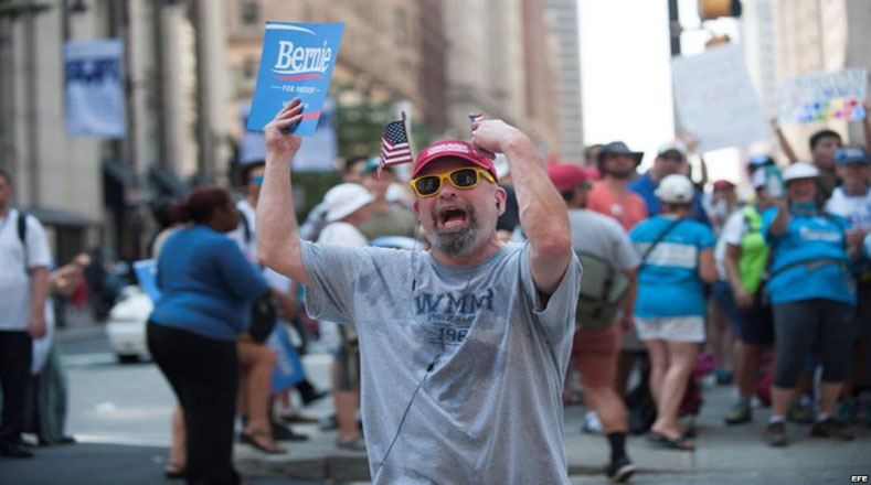Un hombre participa en una manifestación, donde los seguidores de Sanders vitorearon, gritaron lemas e hicieron sonar tambores. 