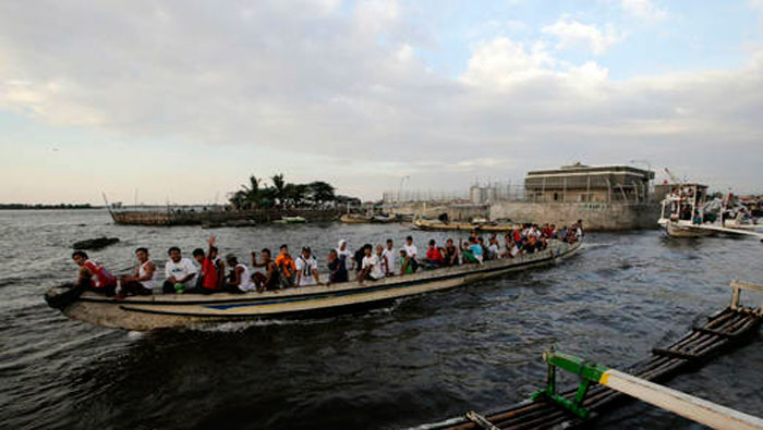 Varios pescadores filipinos vuelven a puerto ante la llegada de fuertes vientos a Manila. (Foto: EFE).