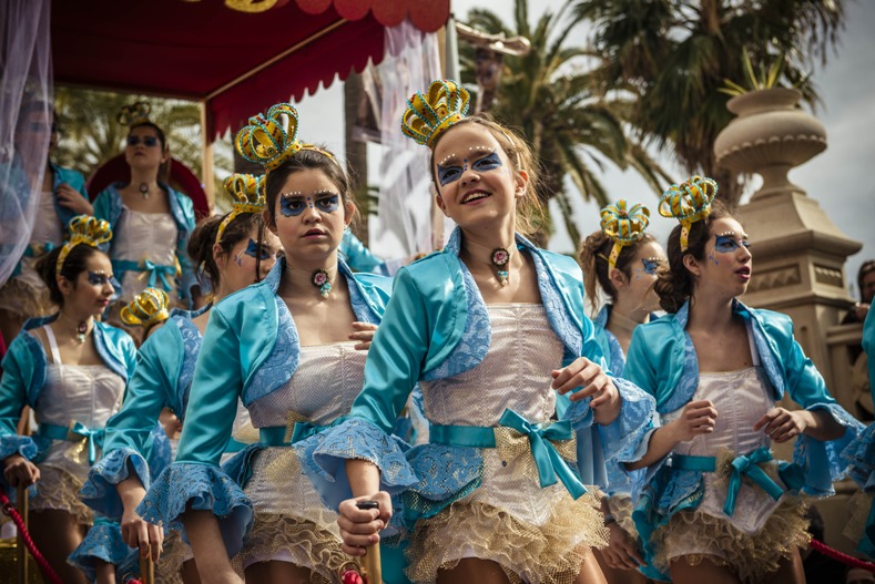 Niñas con coloridos disfraces bailan sobre una carroza durante el Desfile de Niños en el marco de la celebración del Carnaval de Sitges, en la localidad de Sitges, en la provincia de Barcelona, España