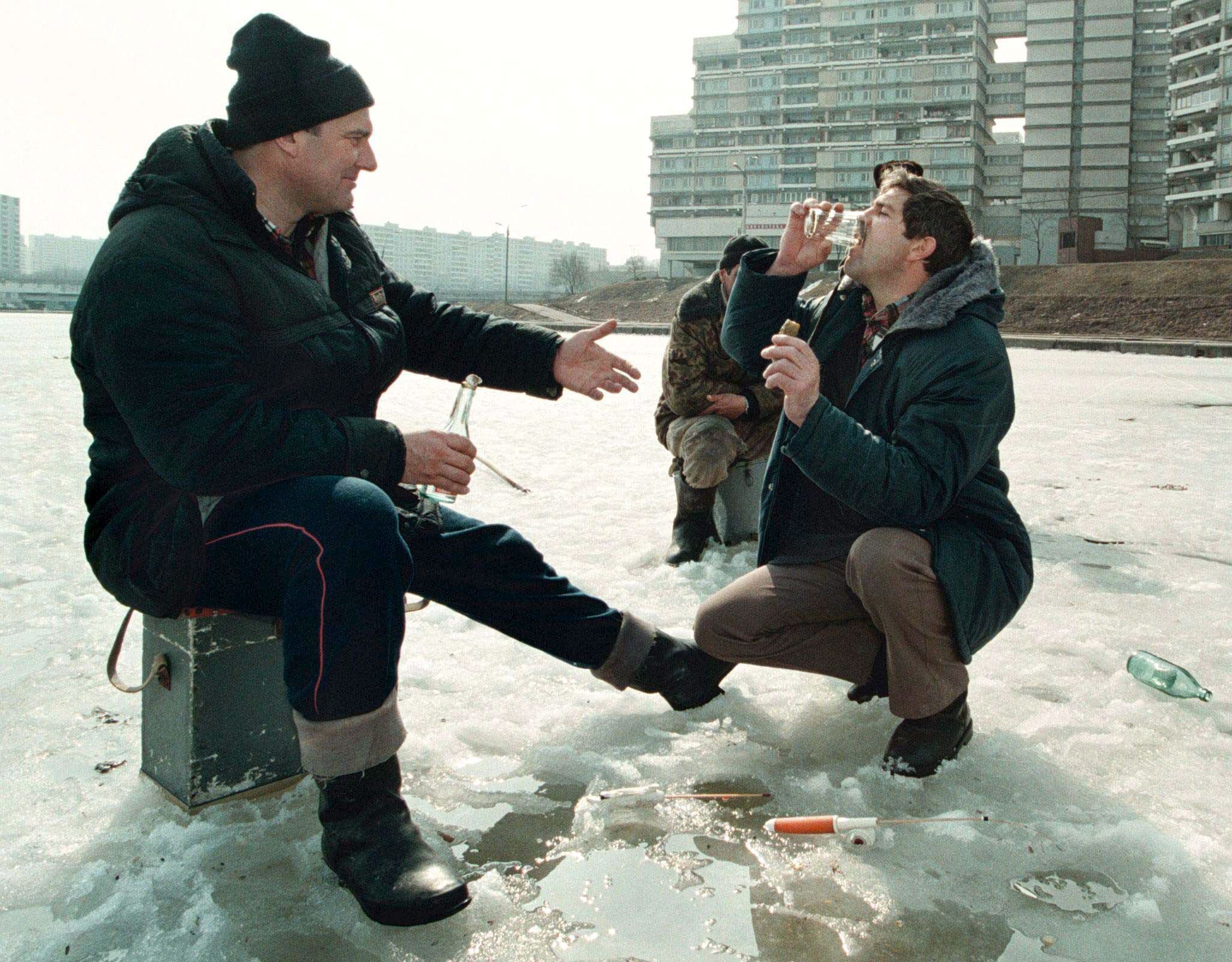 Русские мужики пьют. Алкоголик на улице зимой.