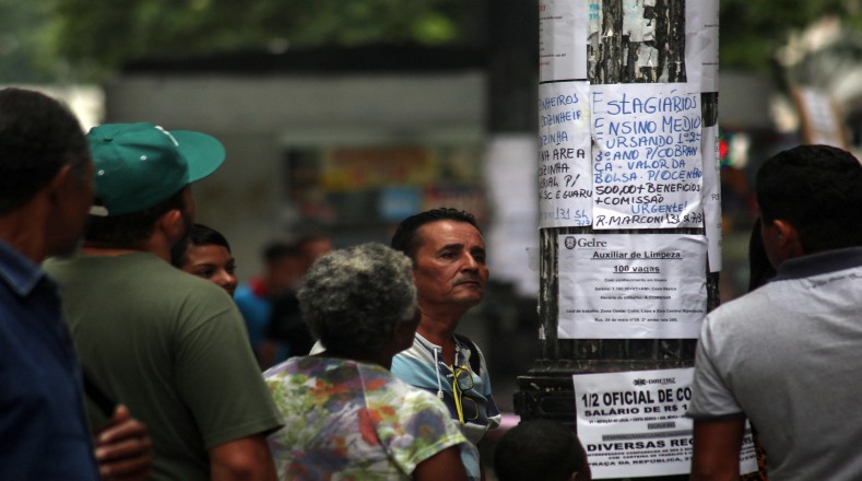 Personas observan las listas de puestos de trabajo pegadas en un poste de Sao Paulo. Según la OIT, en 2017, de cada 3 desempleados nuevos en el mundo, uno será brasileño.