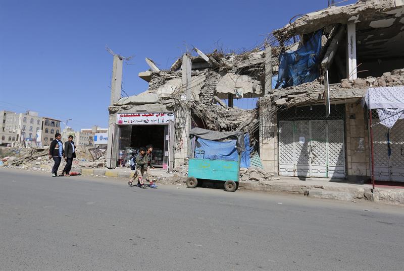 Niños caminan frente a los escombros de un bombardeo saudita.