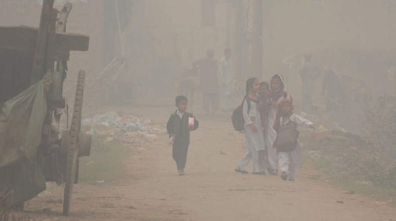 Estudiantes deben caminar entre la densa niebla en Lahore, en el este de Pakistán, para poder asistir a clases.