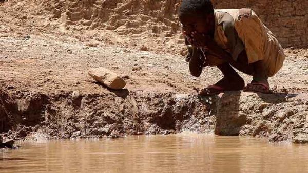 Esta imagen muestra un niño bebiendo agua de un charco ya que en su pueblo tienen dificultad para la obtención de agua.
