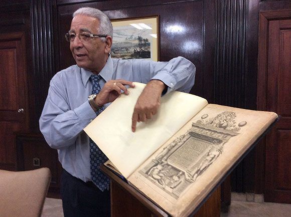 El doctor Eduardo Torres Cuevas hojea las páginas del atlas Theatrum Orbis Terrarum, una de las piezas más valiosas del patrimonio nacional.