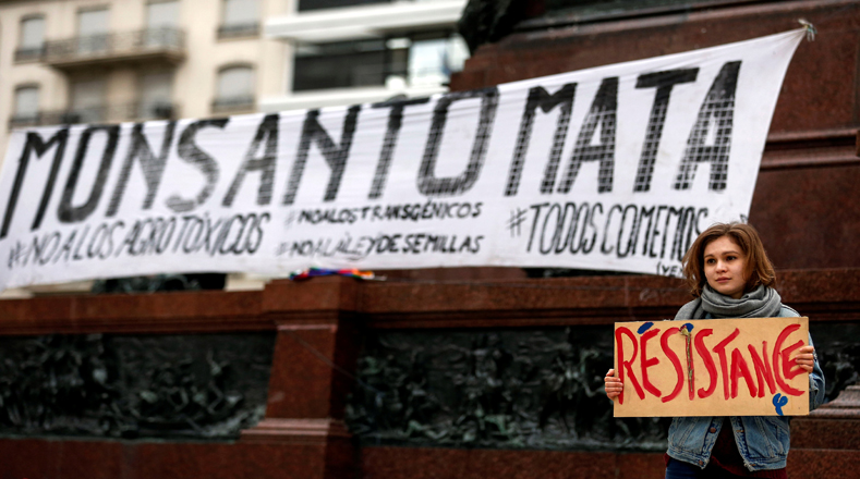 Una manifestante en Buenos Aires con una pancarta que dice "Monsanto mata" en la protesta de este sábado contra el gigante compañía de semillas  Monsanto.