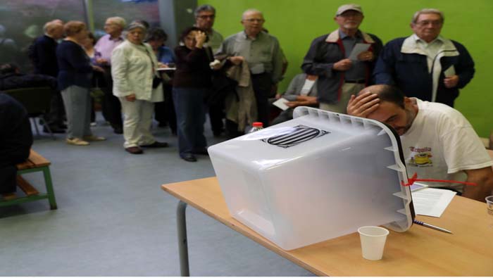 Ciudadanos hacen cola para votar en el barrio de Sants de Barcelona.