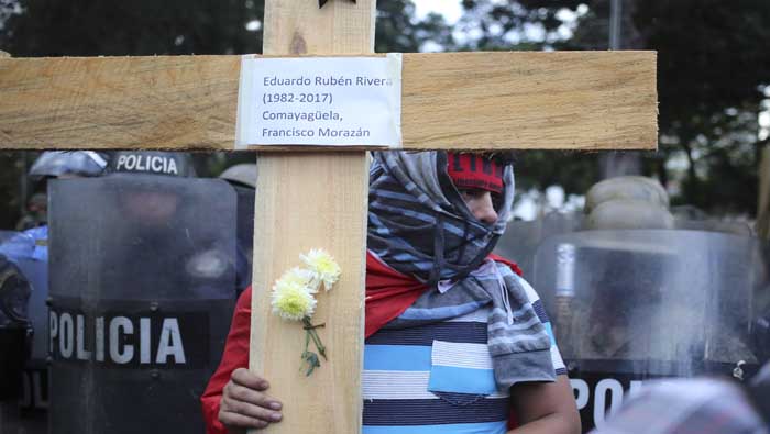 Algunos manifestantes cargaban una cruz de madera con nombres de más de 30 personas que murieron durante las protestas.