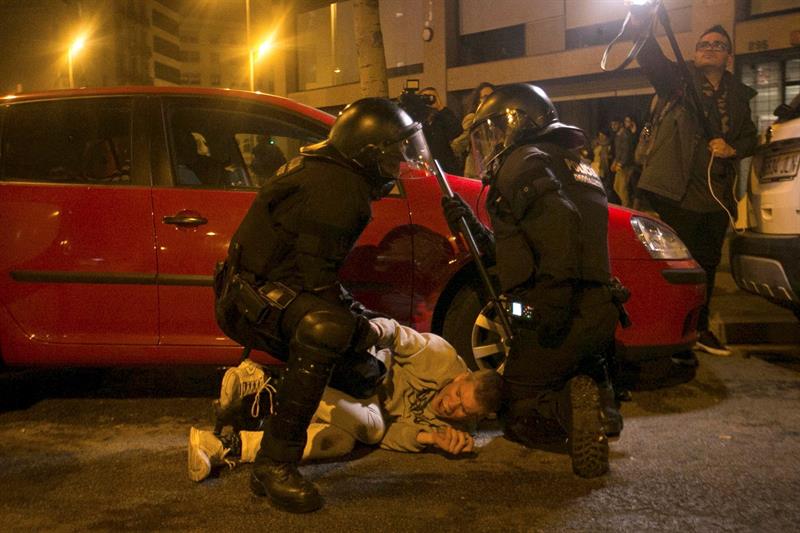 Miembros de los Mossos d´Escuadra reprimen a uno de los participantes en la manifestación frente a la Delegación del Gobierno en Barcelona.