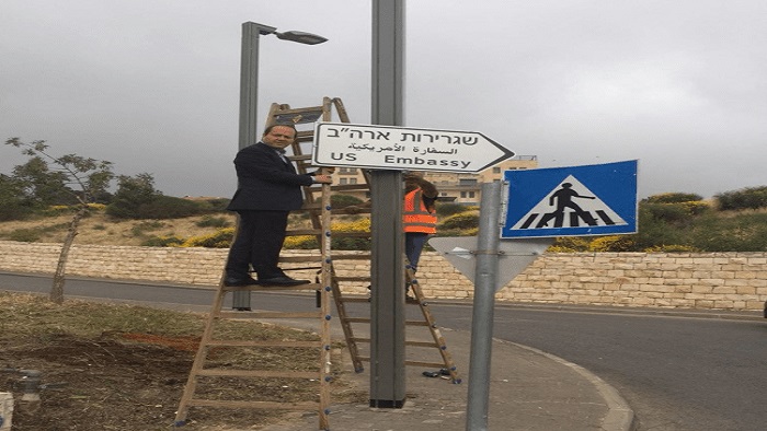 Un grupo de trabajadores han instalado carteles de señalización hacia la sede de la embajada estadounidense al sur de Jerusalén.
