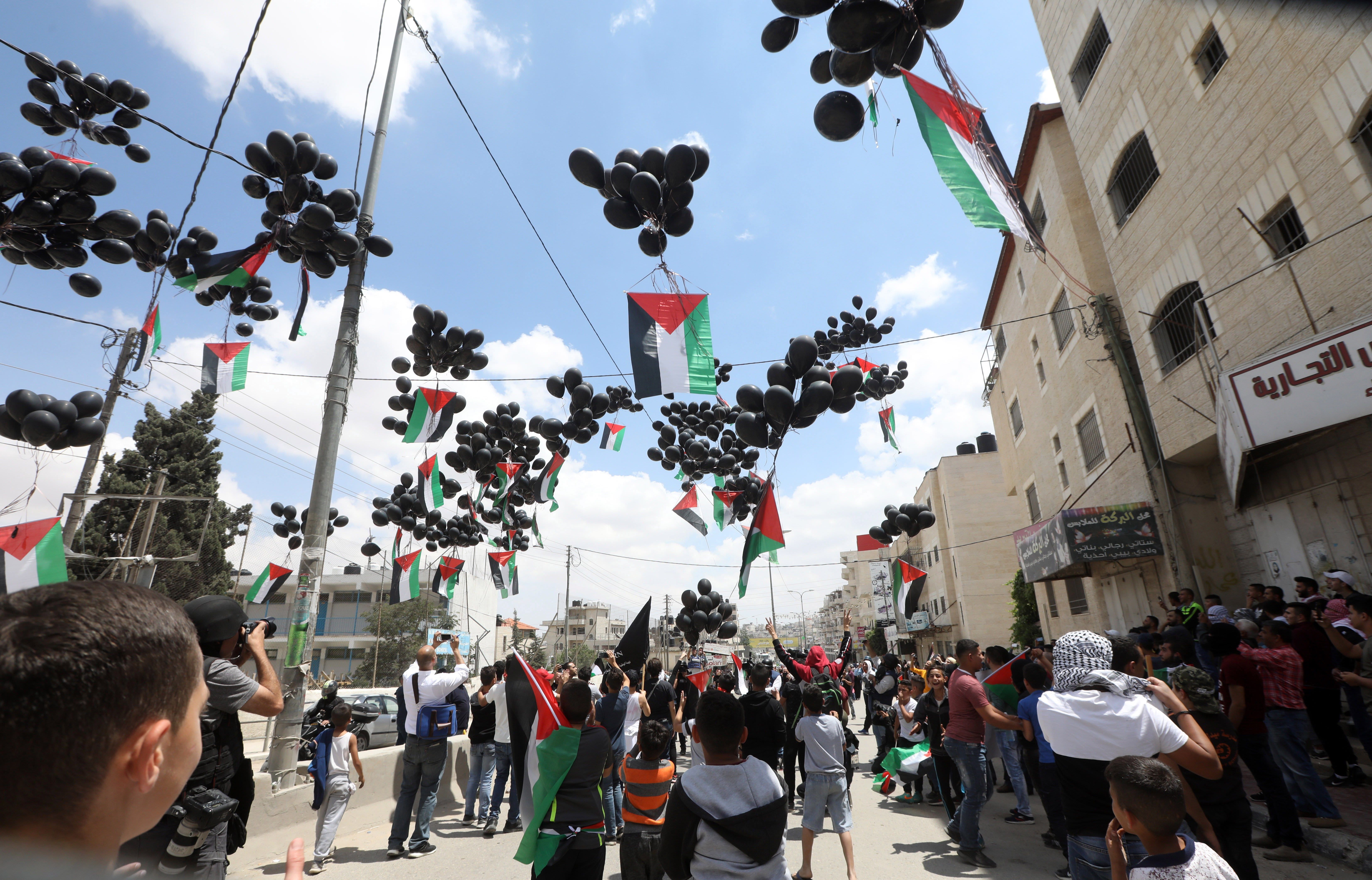 Manifestantes lanzan al aire globos negros con banderas palestinas durante unas protestas en la ciudad cisjordana de Ramala.