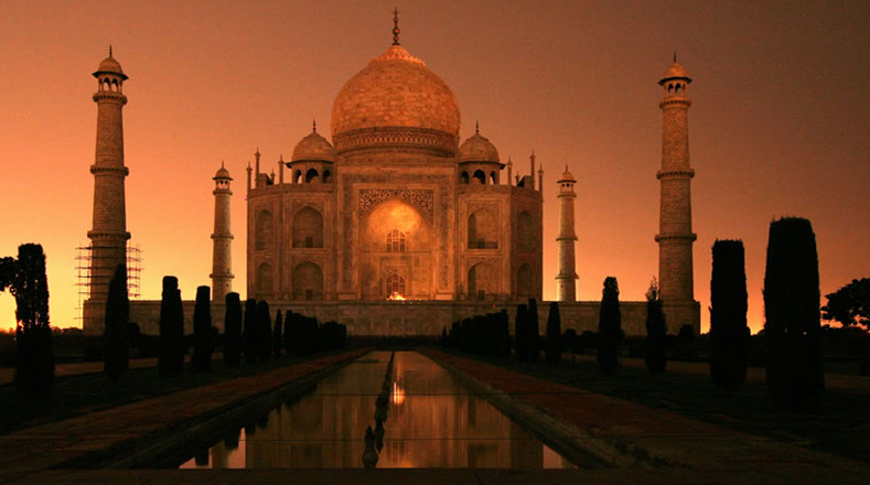 El Taj Mahal en la India coloreado con luces naranjas