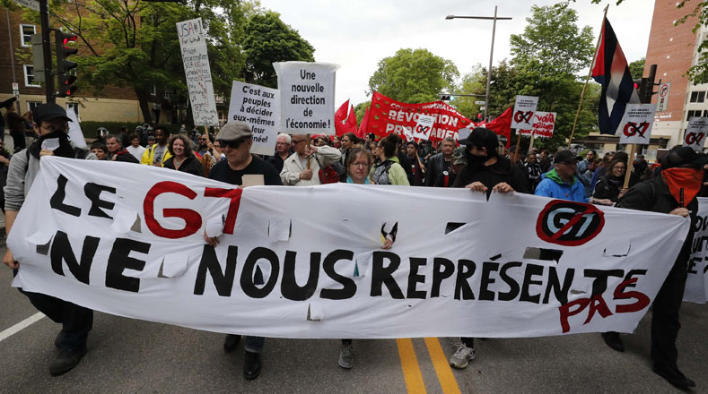 Marchistas portan pancartas con el G7