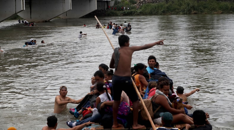 Un grupo de migrantes centroamericanos cruza el río Suchiate en balsas para llegar a México desde Tecún Umán (Guatemala).