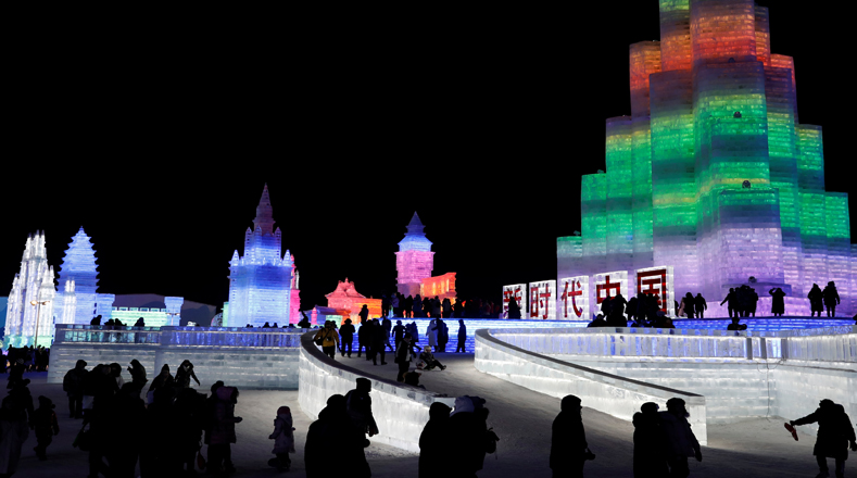 Visitantes caminan alrededor de esculturas de hielo iluminadas durante el festival anual de hielo en Harbin, provincia de Heilongjiang.