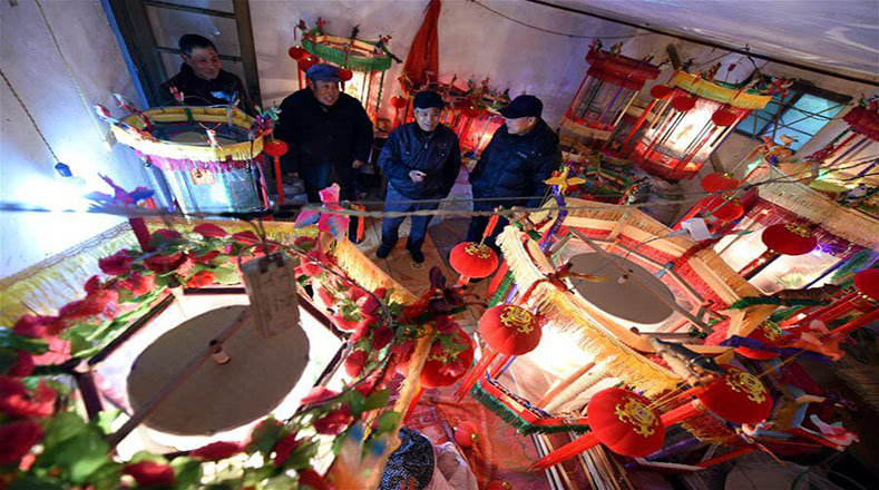 Comerciantes observan lámparas tradicionales chinas con imágenes giratorias, en la villa Wanqqiao, provincia de Shandong, en el este de China.