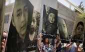 Activistas sostienen fotos de niños migrantes que mueren bajo custodia en EE.UU.